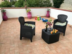 Usini的住宿－Il melograno，庭院里设有两把椅子和一张桌子