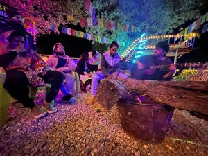 a group of people sitting on a bench at night at Hostel 360 Degree in Manāli