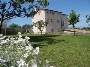 una casa en un campo con flores en primer plano en Apartment Greta en Kanfanar