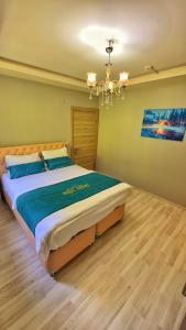 a bedroom with a large bed with a chandelier at Auga Apart in Uzungol