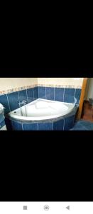 a white tub in a bathroom with blue tiles at PISO HARLEY in Camariñas