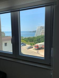 ein Fenster mit Blick auf einen Parkplatz in der Unterkunft Sea's House in Becici