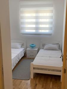 two twin beds in a room with a window at Sea's House in Bečići