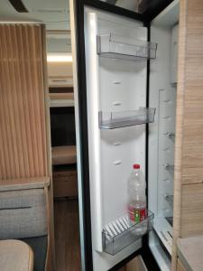 an empty refrigerator with a bottle of water in it at Achziv Beach אכזיב חף in Liman