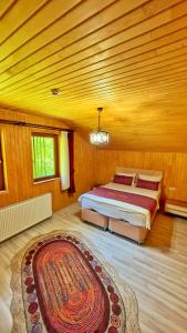 a bedroom with a bed and a rug in a room at Auga Apart in Uzungol