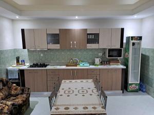 a kitchen with wooden cabinets and a table in it at Casa Elena in 2 Mai