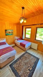a bedroom with two beds and a leopard rug at Auga Apart in Uzungol