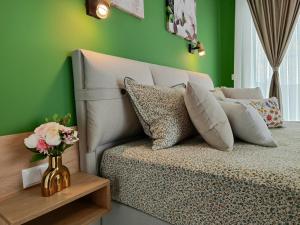 a green bedroom with a bed with a vase of flowers at Аpartment Bella Vista in Obzor +47 photos