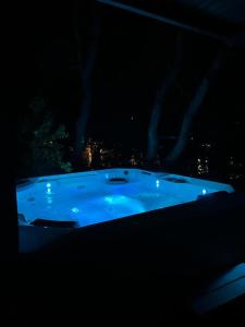 a large blue tub with a city in the background at Apartment by the sea Žirje with private heated hydromassage pool in Žirje