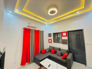 a living room with a couch and red curtains at Appartement T 2 N°2: Résidence LES 11 PLURIELLES 