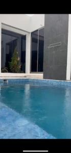 a large blue swimming pool in front of a house at شاليهات بلاسيو 