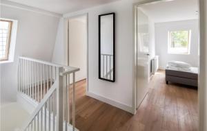 um quarto branco com uma escada e um espelho em Kavel 17 em Den Oever
