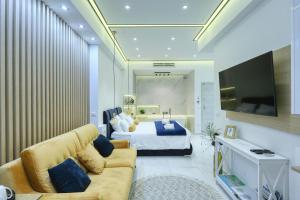a bedroom with a bed and a couch and a television at RINO LUXURY ROOM in Zadar