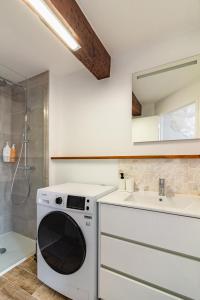 y baño con lavadora y secadora blancas. en Charmant duplex Castelnaudary, en Castelnaudary