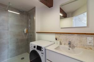 y baño con lavadora y lavamanos. en Charmant duplex Castelnaudary, en Castelnaudary