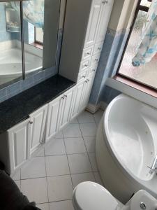 a bathroom with a toilet and a sink and a window at Quite Broad Resr 1 in Longford