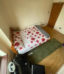 um pequeno quarto com uma cama com flores vermelhas em Quite Broad Resr 1 em Longford