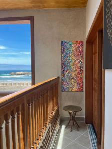 einen Blick auf den Strand von einem Balkon mit einem Gemälde an der Wand in der Unterkunft Riad Mellah in Essaouira