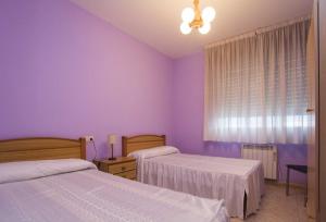 - une chambre violette avec 2 lits et une fenêtre dans l'établissement Pitis, à Bueu
