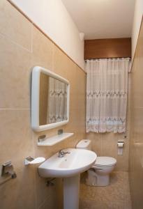 La salle de bains est pourvue d'un lavabo, de toilettes et d'un miroir. dans l'établissement Pitis, à Bueu