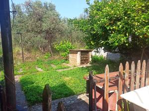 un jardín con un banco y una valla de madera en Zephyr Guest House, en Lefokastro