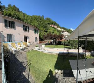 un jardín con sillas, un edificio y un patio con césped en dream house, en Stazzema