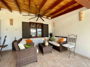 a living room with wicker furniture and a wooden ceiling at Villa Buena Vista in Palmanova