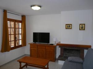 una sala de estar con sofá y TV en un armario en Inocencia, en Alcossebre