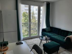 パリにあるMagnifique Studio de 25 m2のリビングルーム(緑のソファ、窓付)