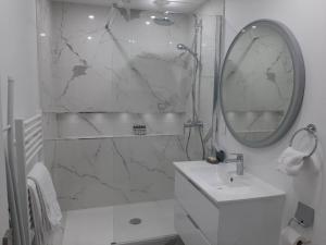 bagno bianco con lavandino e specchio di Magnifique Studio de 25 m2 a Parigi