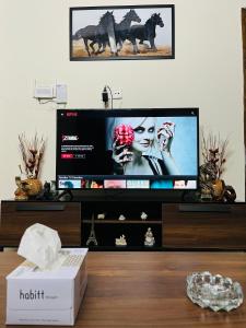 a flat screen tv sitting on top of a table at Entire 2BR Apartment, Netflix, Prime in Islamabad
