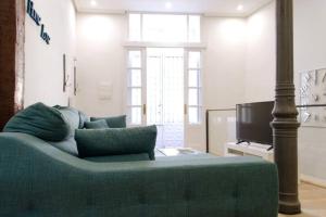 sala de estar con sofá azul y TV en Apartamento Palacio Real de Madrid, histórico en Madrid