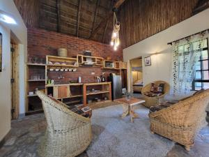 Edaala Comfort - B&B في نيروبي: غرفة معيشة مع كراسي الخوص وجدار من الطوب