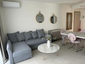 a living room with a blue couch and a table at Dina's Holiday Apartment with Pool in Nikiti in Nikiti