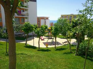 un parque con árboles y un parque infantil en un edificio en Apartament Sea Fort Club Grand Resort Fort Noks Sveti Vlas-Bastet BS en Elenite