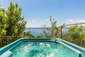 a hot tub with a view of the water at Blu Breeze Apartments in Lokva Rogoznica