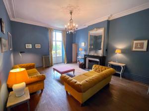 ein Wohnzimmer mit 2 Sofas und einem Kamin in der Unterkunft Beautiful 6 bedroom house with pool & large garden in Le Pêchereau