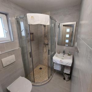 y baño con ducha, aseo y lavamanos. en Apartmány nad Tajovom, en Banská Bystrica