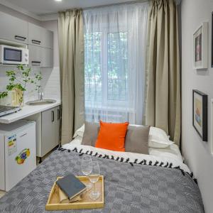 a small bedroom with a bed with an orange pillow at Astoria Apartments in Almaty