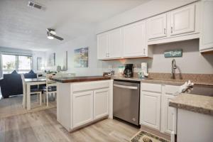 a kitchen with white cabinets and a dining room at 5 stars Peaceful Condo - 7 min walk to the beach in Hilton Head Island