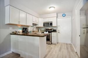 a kitchen with white cabinets and a counter top at 5 stars Peaceful Condo - 7 min walk to the beach in Hilton Head Island