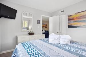 Schlafzimmer mit einem Bett mit Kissen und einem TV in der Unterkunft 5 stars Peaceful Condo - 7 min walk to the beach in Hilton Head Island