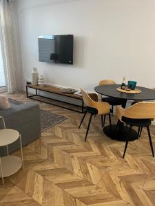 a living room with a tv and a table and chairs at Apartament Elle in Malbork