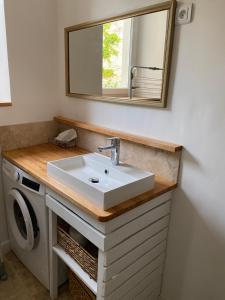 a bathroom with a sink and a washing machine at La Romance de Grignan in Grignan +12 photos