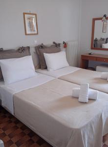 2 Betten in einem Hotelzimmer mit Handtüchern darauf in der Unterkunft Castro Hotel in Monemvasia