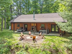 a small house with a patio and picnic tables at Stunning Views, Superb Atmosphere, Modern Amenities, In the Middle of Nature in Bryson City
