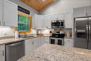a kitchen with white cabinets and stainless steel appliances at Stunning Views, Superb Atmosphere, Modern Amenities, In the Middle of Nature in Bryson City