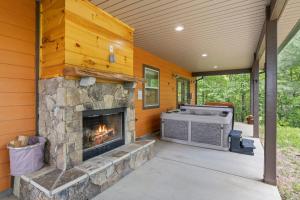 an outdoor patio with a fireplace and a grill at Stunning Views, Superb Atmosphere, Modern Amenities, In the Middle of Nature in Bryson City