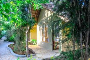 a house with trees in front of it at Hillstone Safari Lodge in Kimana