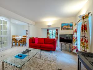 a living room with a red couch and a table at Campbells Close Apartment in Edinburgh